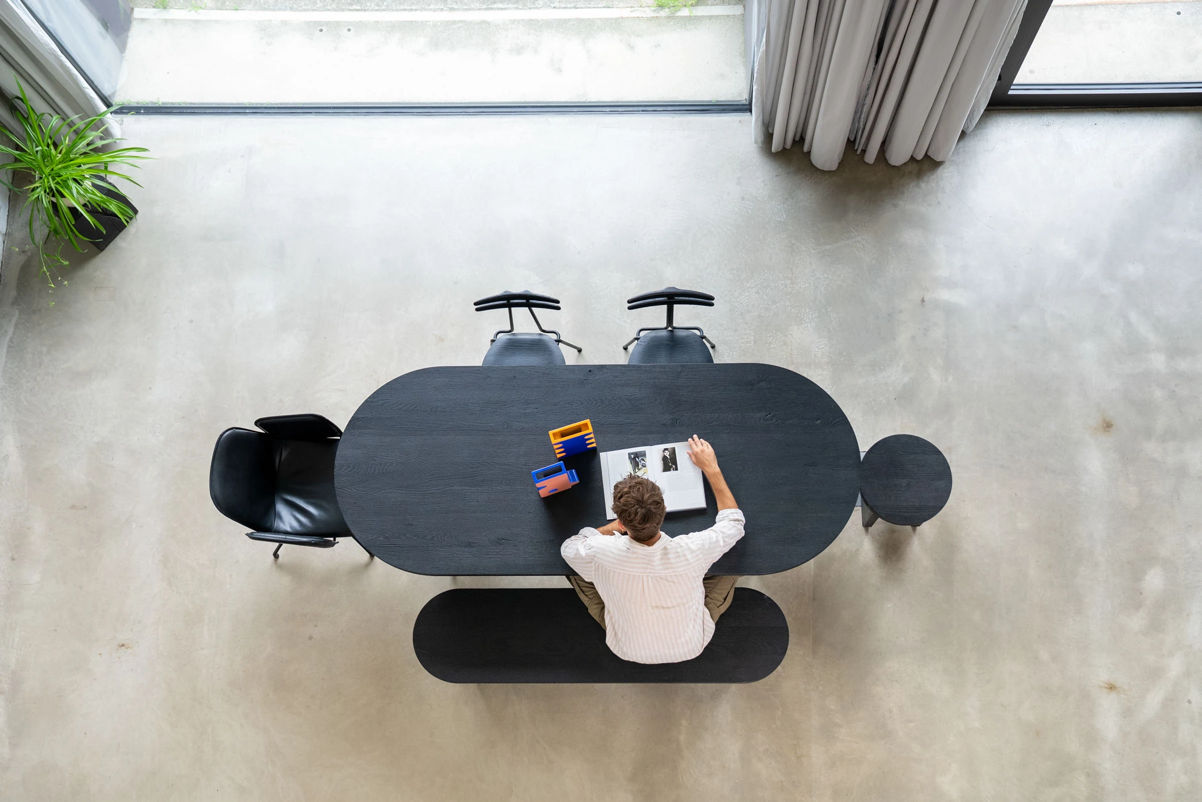 Working at the black oval table, seen from the gallery