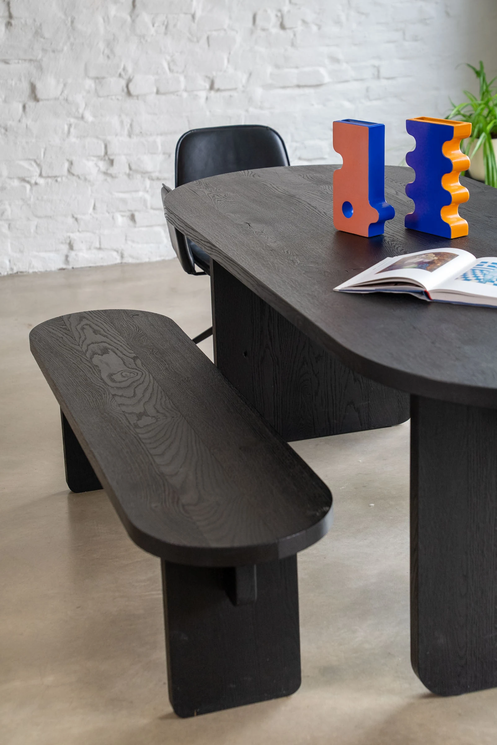 The black oak table and bench with ceramics and a book